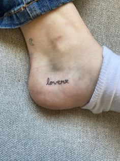 a woman's foot with the word love tattooed on her left side and an inscription below it