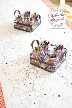 two trays filled with crayons sitting on top of a white tablecloth