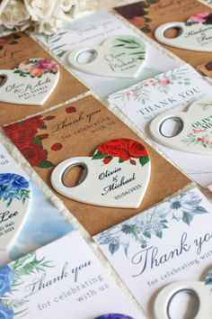 wedding thank you tags are laid out on top of each other, with flowers in the background