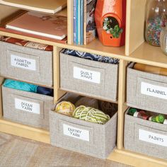 three bins with labeled labels on them in front of a bookcase filled with books