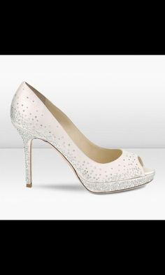 a pair of white high heels with crystals on them