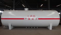 a large white tank sitting inside of a warehouse next to another building with red lettering on it