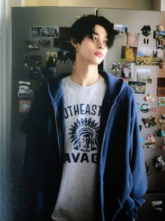 a young man standing in front of a refrigerator