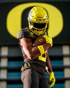 a football player holding a ball in his right hand and wearing a helmet with the letter o on it