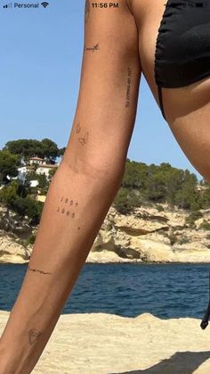 a woman's legs with tattoos on the beach