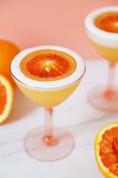 three glasses filled with orange juice and garnished with an orange slice