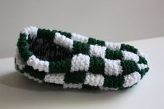 a green and white crocheted basket sitting on top of a table