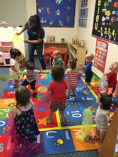 a woman teaching children how to play in a classroom