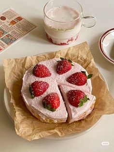 there is a cake with strawberries on it and a cup of coffee next to it