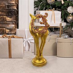 a gold horse statue next to presents and a christmas tree