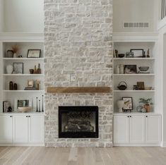 a living room filled with furniture and a fire place in front of a stone fireplace