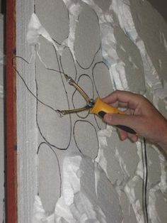 someone is using scissors to cut the fabric off of a piece of wall paper that has been taped together