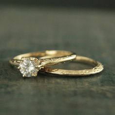 two gold wedding rings with a single diamond