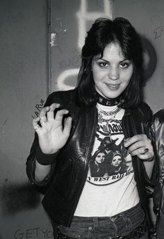 black and white photograph of a woman in leather jacket holding her hand up to the camera