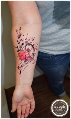 a person with a heart tattoo on their arm