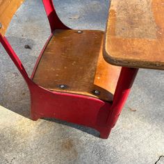 an old school desk and chair are sitting on the concrete floor next to each other