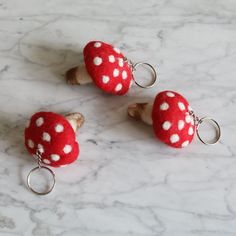 three red and white polka dot keychains sitting on top of a marble counter