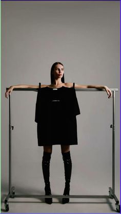 a woman standing in front of a metal rack with her arms on the top of it