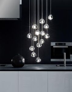 a black and white kitchen with lots of lights hanging from the ceiling