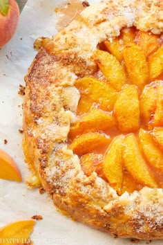 an apple pie with powdered sugar on top and sliced peaches around the edges