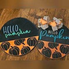 two black and orange paper pumpkins with hello pumpkin written on the front, one has a bow