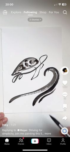 someone is holding up a drawing in front of their cell phone with the image of a fish on it