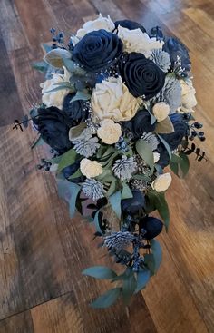 a bridal bouquet with blue and white flowers on a wooden floor in a room