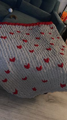 a bed covered in a blanket with red birds on it