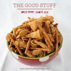 the good stuff best ever snack mix is in a red and green bowl on a white cloth