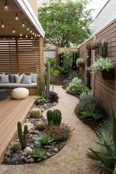 an outdoor patio with lots of plants and rocks on the ground, along with lights strung from above