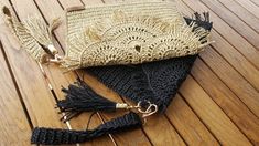 a straw purse sitting on top of a wooden floor next to a hook and tassel