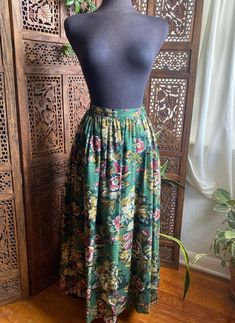 "90s green floral midi skirt by Charter Club. Buttons closed, pleated in the waist and has pockets. 100% rayon Excellent vintage condition! No stains or holes. Always use measurements for more accurate sizing. Tag labels are meaningless. This is slightly pinned on my modern 6/S mannequin. Go by measurements. Measurements taken laying flat/Double number where applicable: WAIST: 15\" across LENGTH: 35.5\" ALL SALES ARE FINAL SO PLEASE DOUBLE CHECK THE MEASUREMENTS PRIOR TO BUYING AND DON'T HESITATE TO REACH OUT IF YOU HAVE ANY QUESTIONS!  All items are vintage/preloved and may have small imperfections. This should be expected for secondhand clothing. ALL MAJOR FLAWS WILL BE NOTED IN THE DESCRIPTION AND PHOTOGRAPHED." Green Floral Print Long Skirt, Green Bohemian Maxi Skirt With Floral Print, Retro Green Long Skirt Bottoms, Green Floral Print Flowy Skirt, Retro Green Long Skirt, Bohemian Green Pleated Skirt, Retro Green Midi Skirt, Retro Green Pleated Bottoms, Vintage Green Skirt For Summer