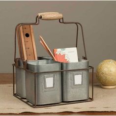 a metal basket with two bins holding books and pencils