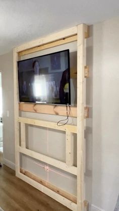 a flat screen tv mounted to the side of a wall in a living room under construction