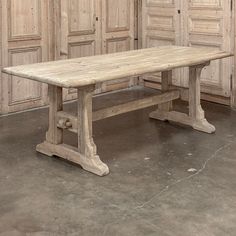 an old wooden table sitting in front of some doors