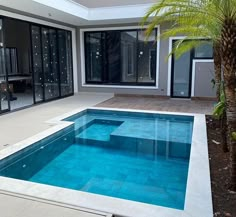 an empty swimming pool in the middle of a house with glass doors on both sides