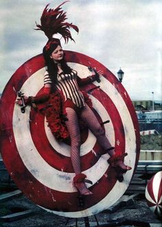 a woman dressed in costume is laying on top of a target with her legs spread out