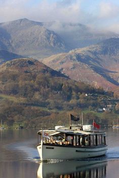 a boat on the water with mountains in the background