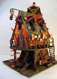 a small house made out of wood and other things on top of the tree stump