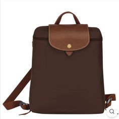 Longchamp Le Pliage Original Folding Medium Backpack. Brown Color Called “Ebony”. Longchamp Le Pliage Collection Combines Heavy Nylon With Tan Grained Leather Trim In Classically Cool Styles. A Necessary Basic The Totes And Backpacks Fold/Unfold For Extra Use. Zip Top Closure. Goldtone Hardware. 11 X 10.2 X 3.9 Longchamp Bags, Medium Backpack, Longchamp Le Pliage, Zip Top, Leather Trim, Leather Trims, Brown Color, Cool Style, Bag Lady