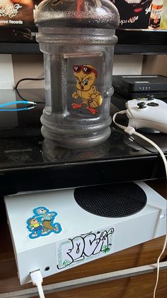 an electronic device sitting on top of a table next to a video game controller and mouse