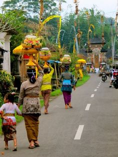 people walking down the street carrying items on their heads