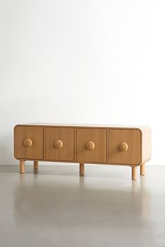 a wooden cabinet with four knobs on the front and two drawers in the back