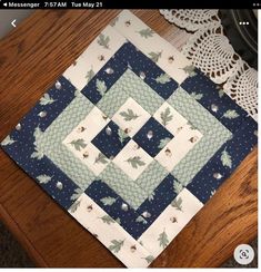 a close up of a table top with a quilt on it and a doily