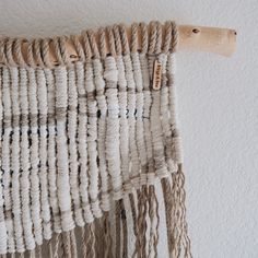 a close up of a piece of cloth hanging from a hook on a white wall