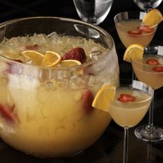 several glasses filled with drinks and garnished with strawberries on the rims