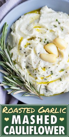 roasted garlic mashed cauliflower on a blue plate with rosemary garnish