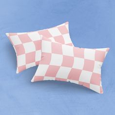 two pink and white checkered pillows on a blue background