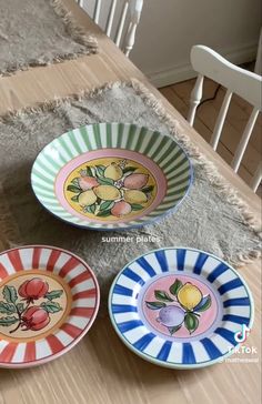 three plates sitting on top of a wooden table next to a rug and white chair