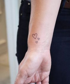 a small heart tattoo on the wrist